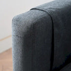 Canapé d'angle 4 places en tissu gris foncé avec pouf et accoudoir de rangement